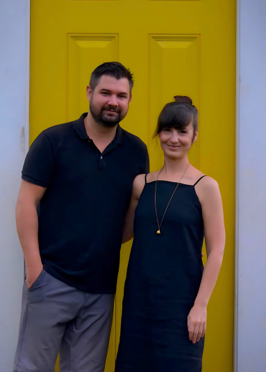 Chef Bill Horodecky and Andrea Coull standing in front of a yellow door.