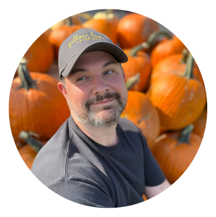 Chef Bill Horodecky sitting amongst pumpkins.